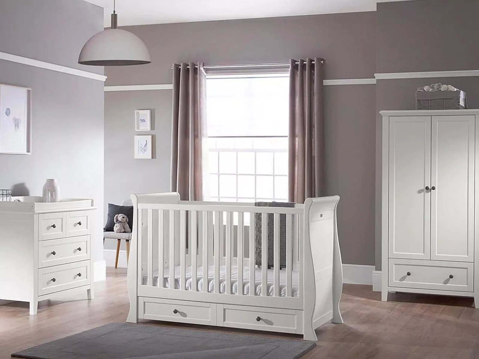 Modern nursery with white cot, dresser, and wardrobe against grey walls. Large window with sheer curtains.