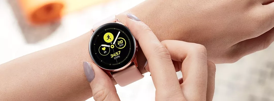 A smartwatch with a pink strap on someone's wrist