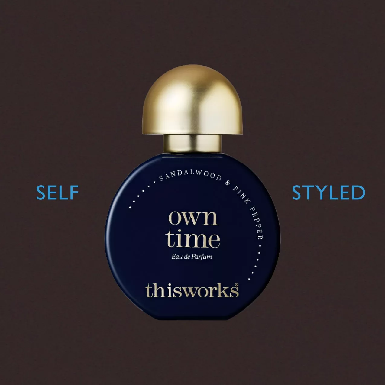 Elegant dark blue perfume bottle with a gold cap, featuring "own time" and "thisworks" branding in white.