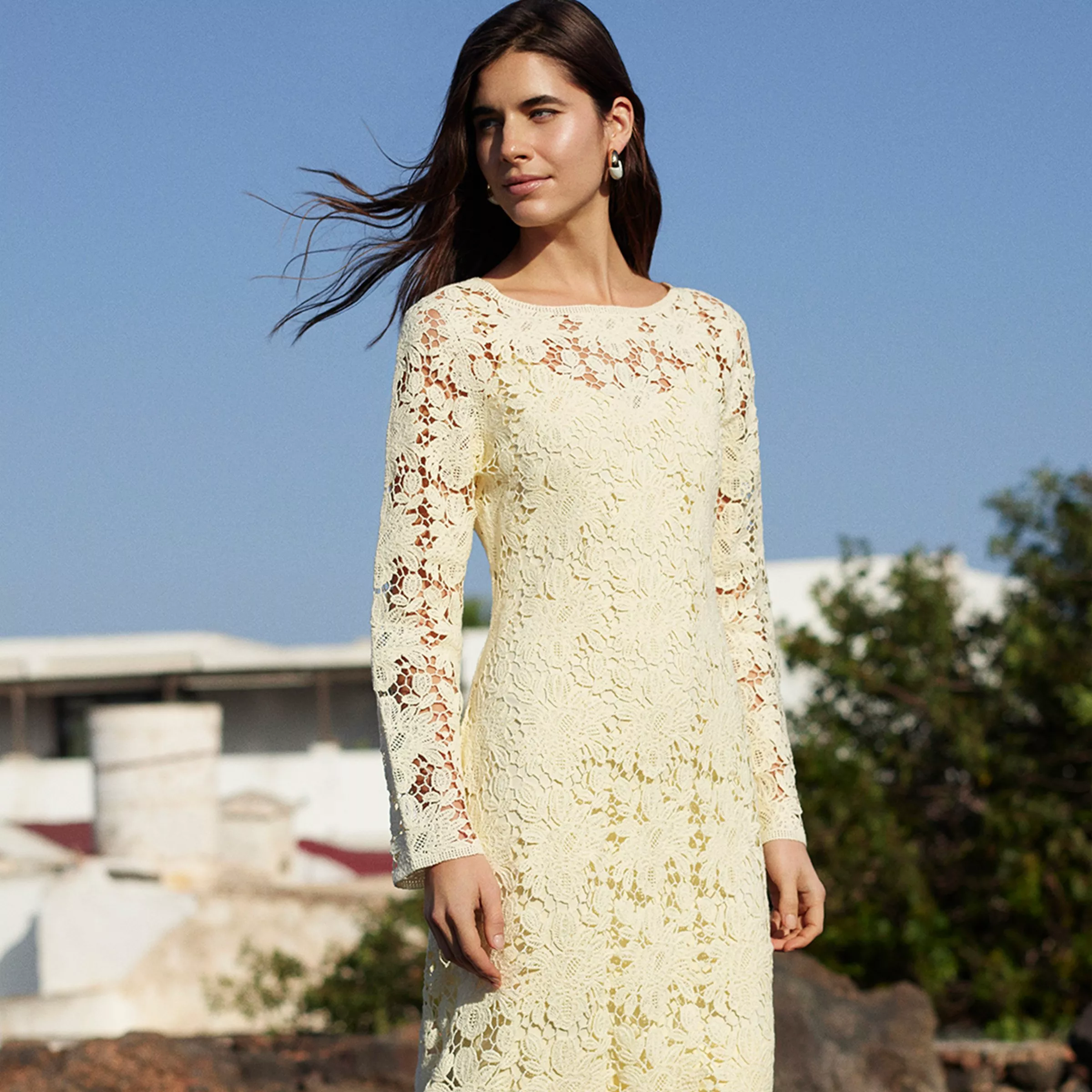 Woman modelling cream floral lace long-sleeve dress outdoors under blue sky, elegant spring summer fashion look