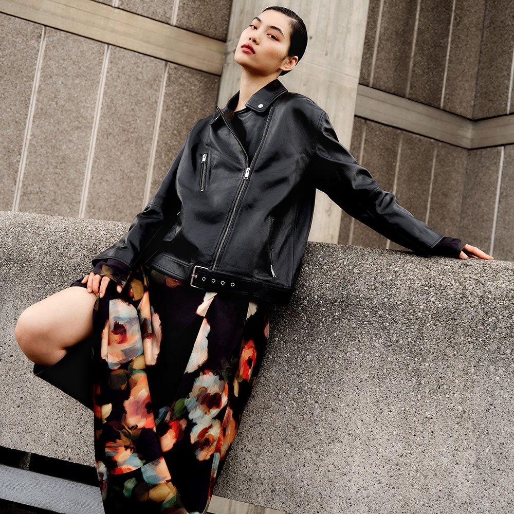 Female model wearing a floral dress and biker jacket