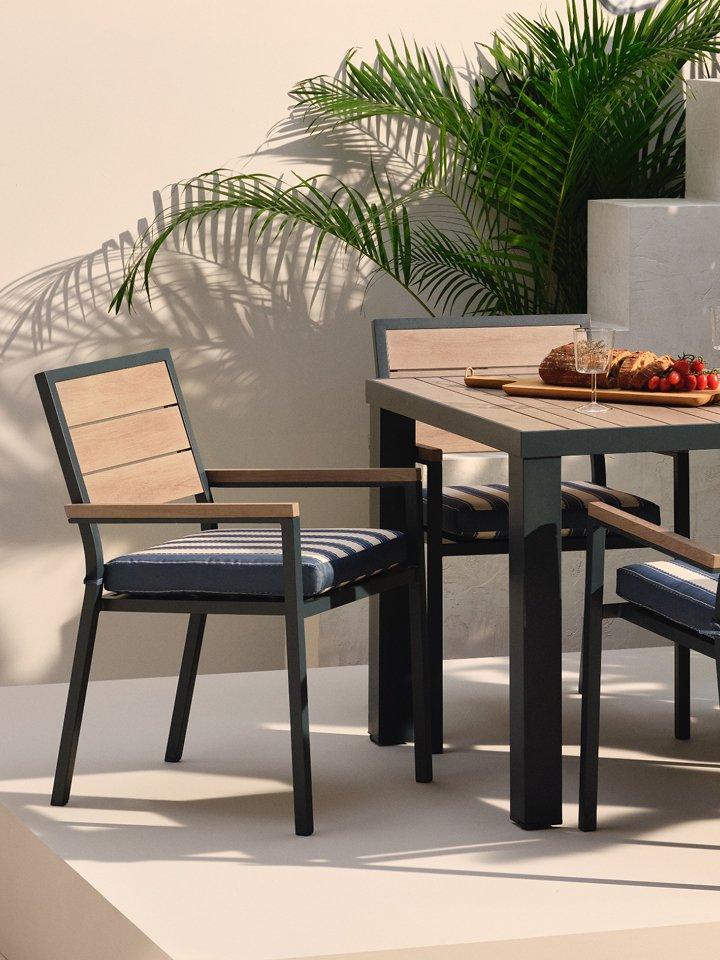 Outdoor dining furniture displayed alongside some plants.