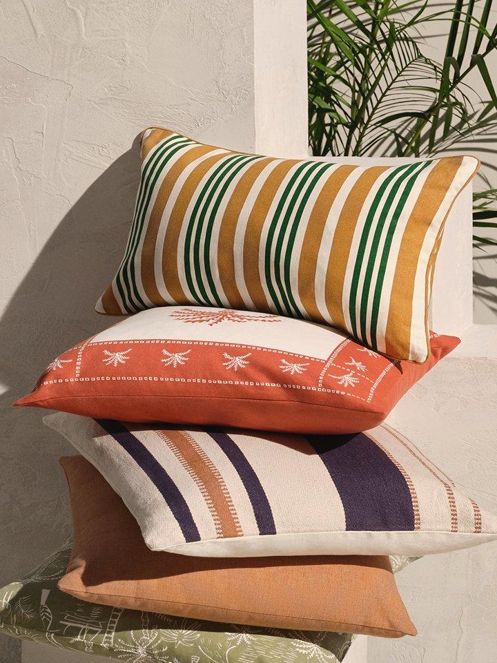 Various patterned and coloured cushions stacked