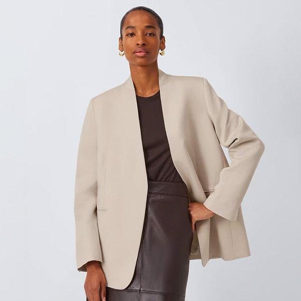 Woman in a beige blazer, brown top, and dark brown skirt.