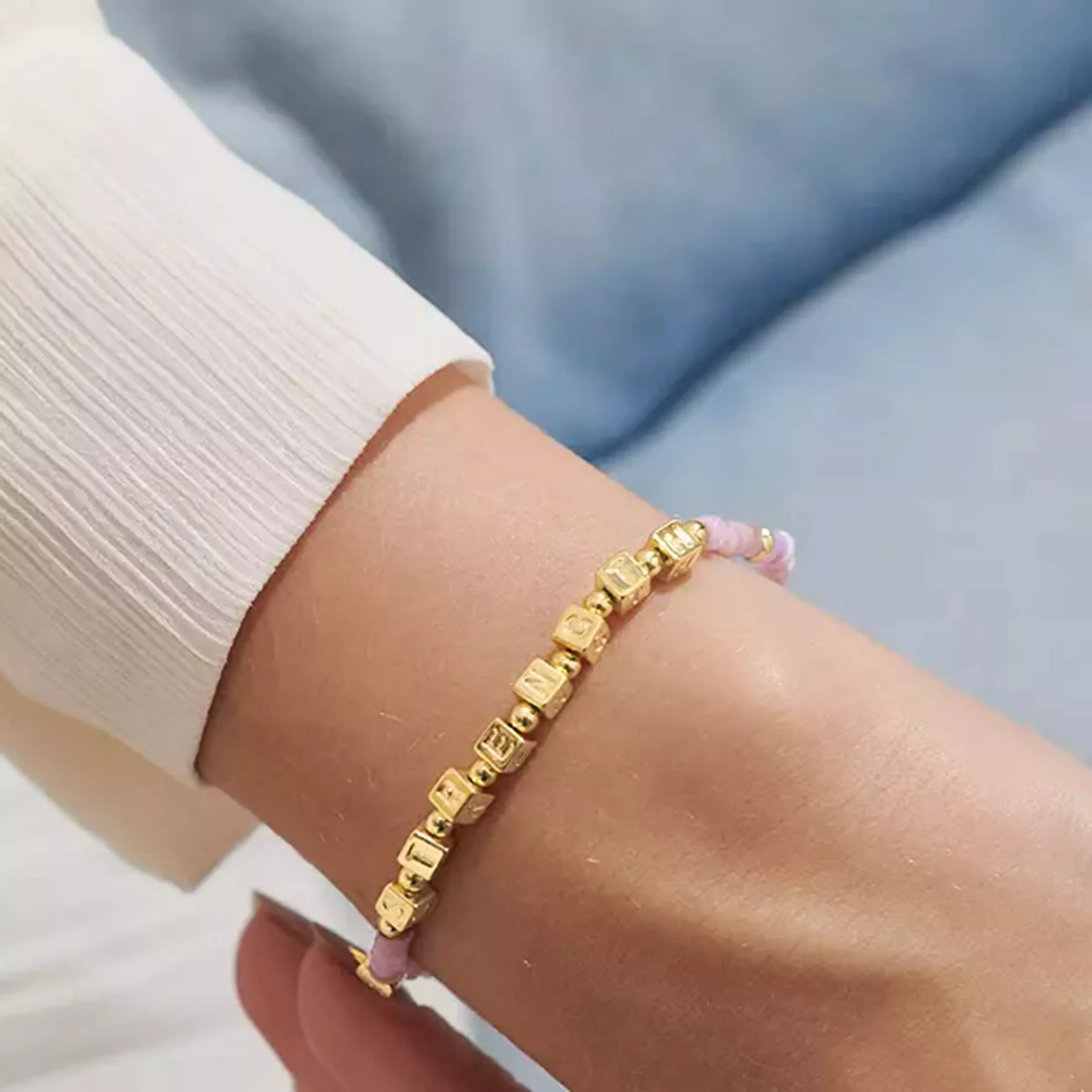 lady's wrist wearing gold bracelet