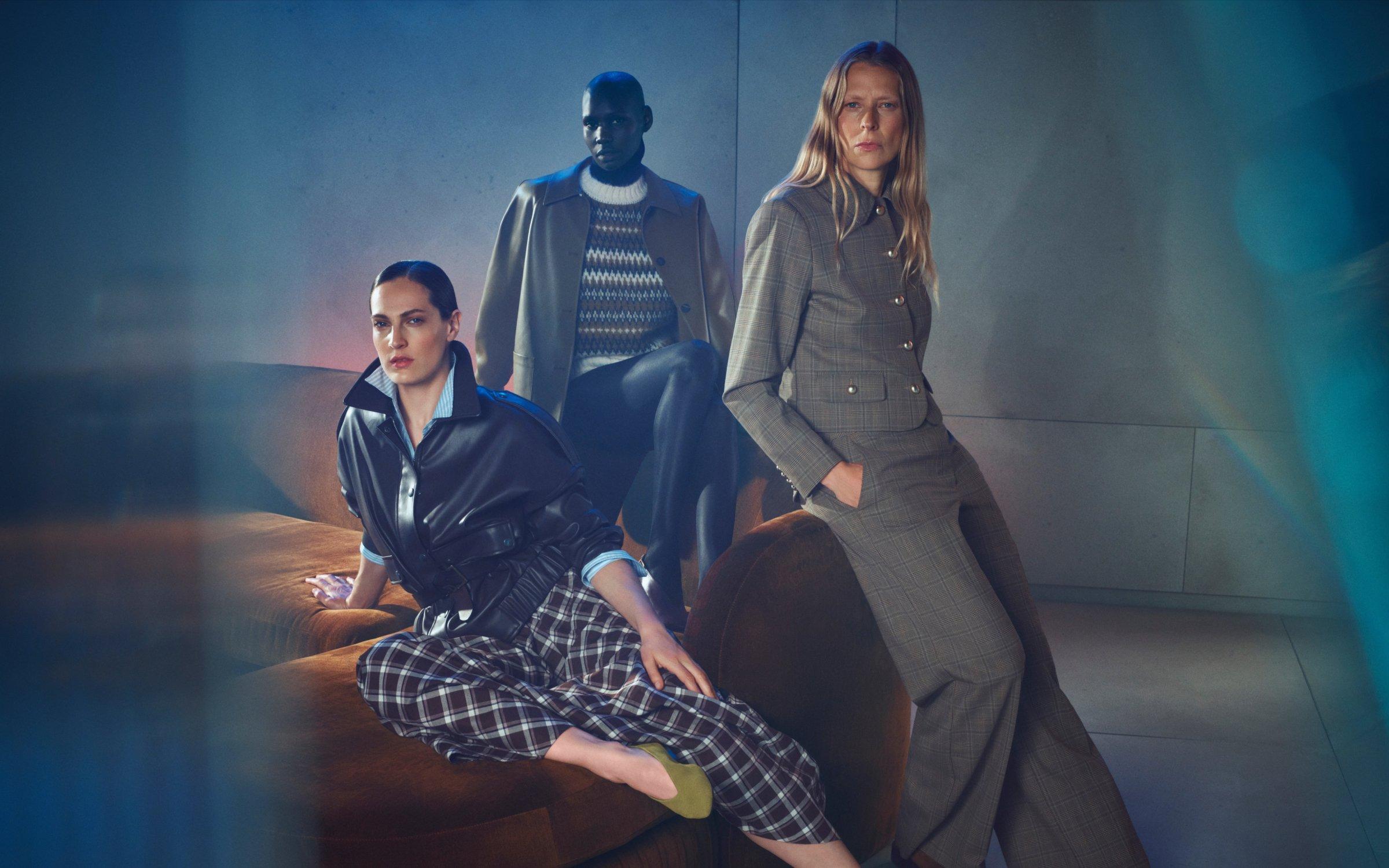 3 women dressed in work smart cool clothes with a minimal modern background