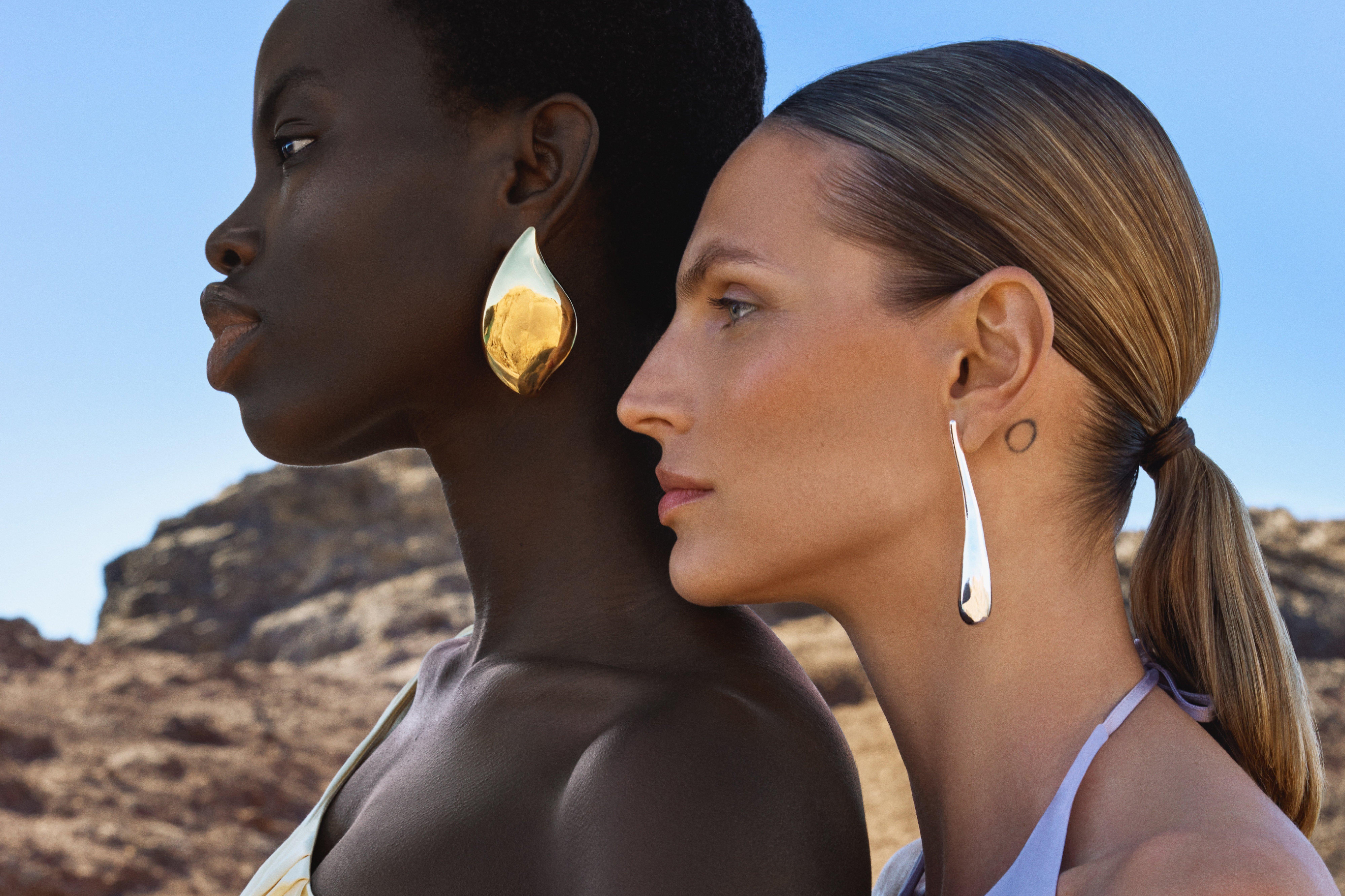 2 women wearing big bold earings and evening dresses