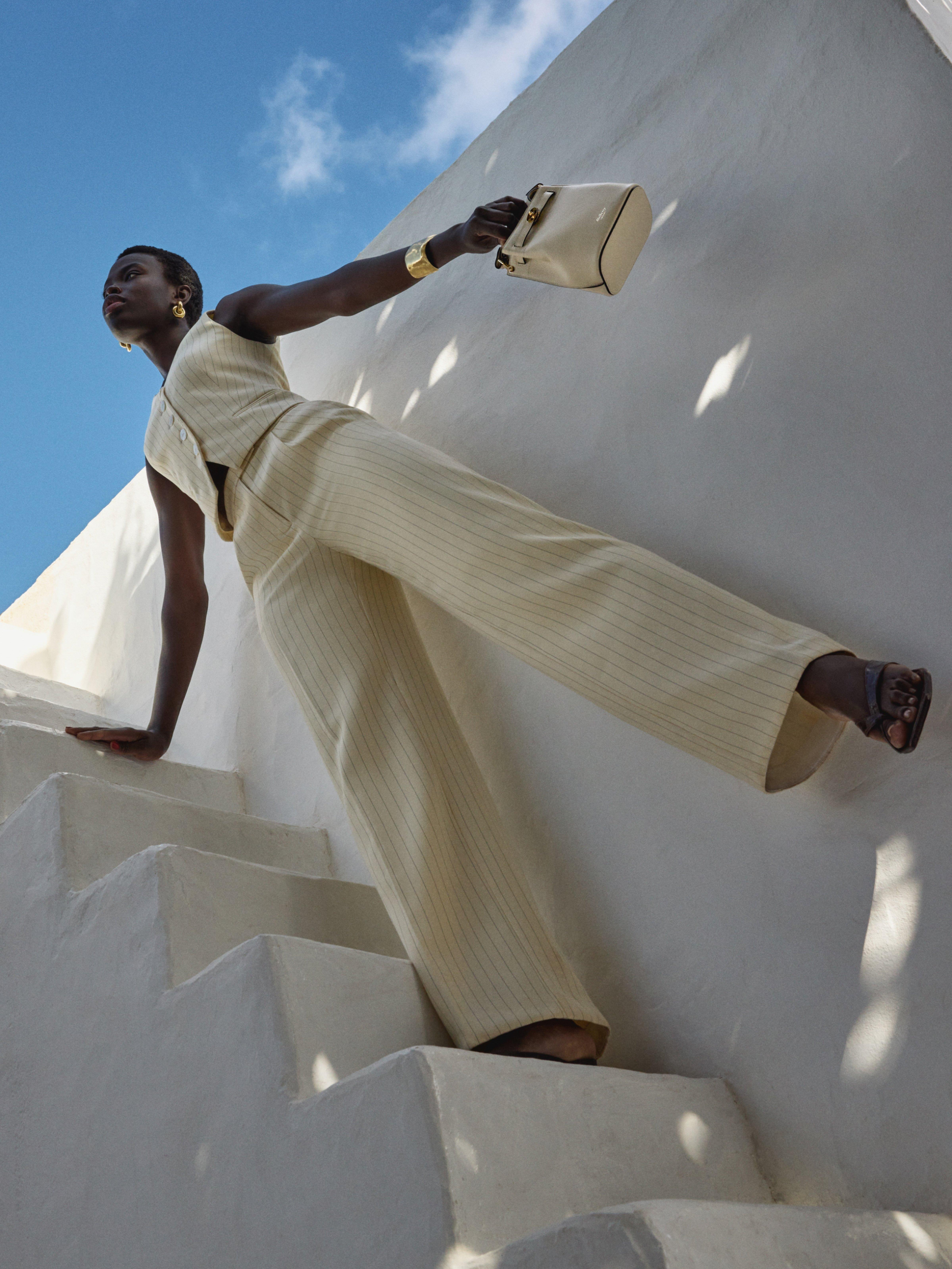 women wearing a smart stiped trouser suit walking down some steps