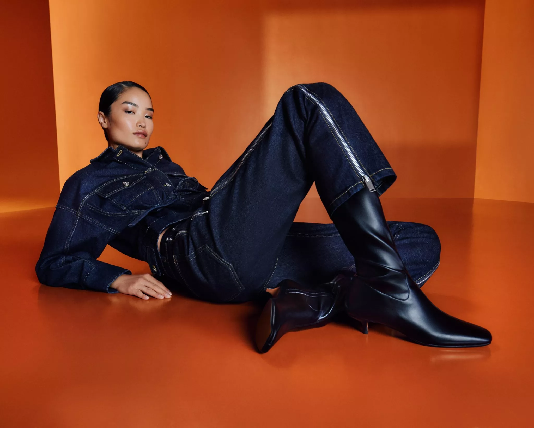 a women in philip lim clothing sitting in a orange room set