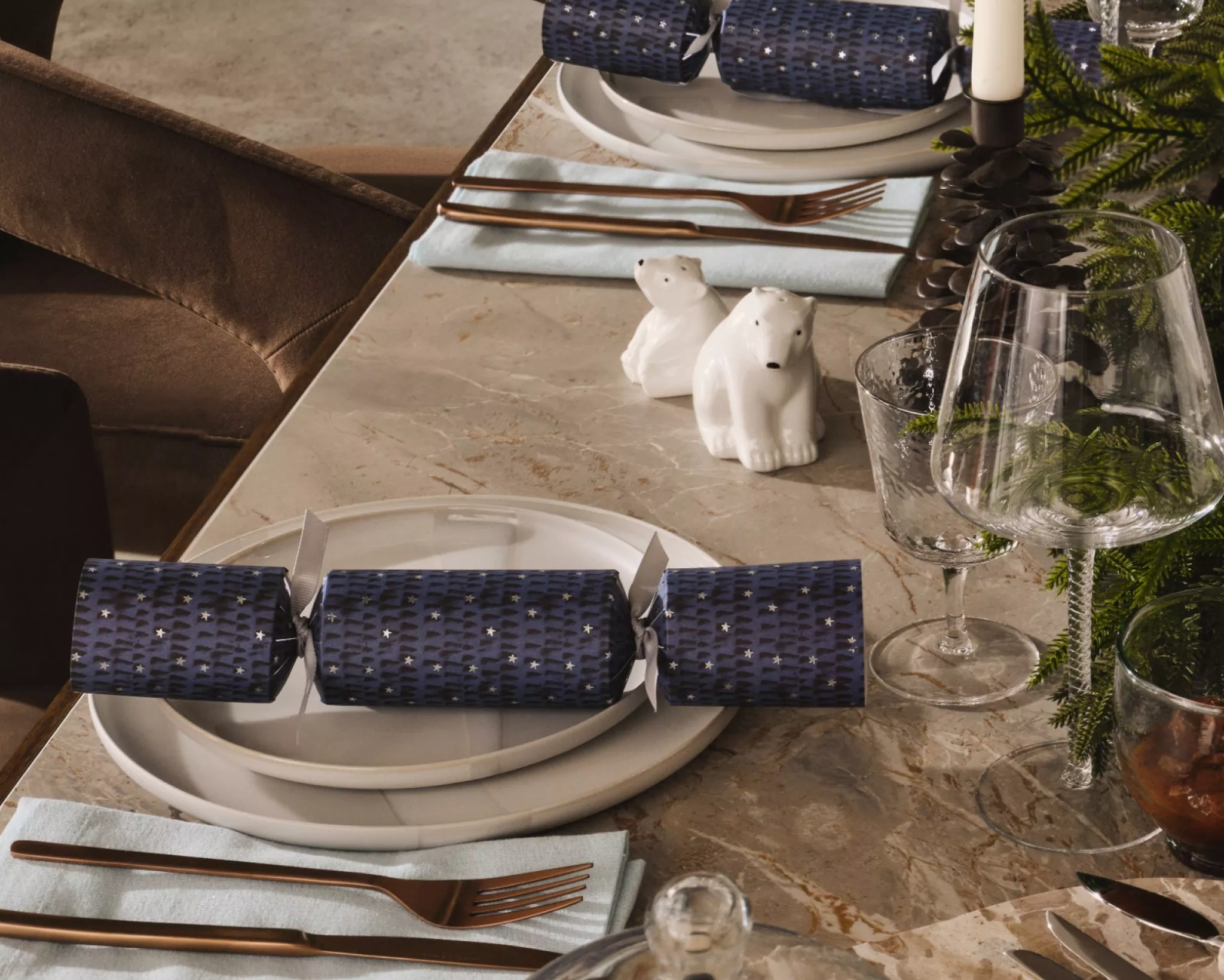 Christmas cracker placed on a plate that's dressed in Scandi Christmas theme