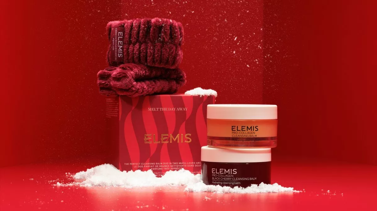 Elemis Pro-Collagen cleansing balm gift set with two jars, red box and headband on festive red background with snow