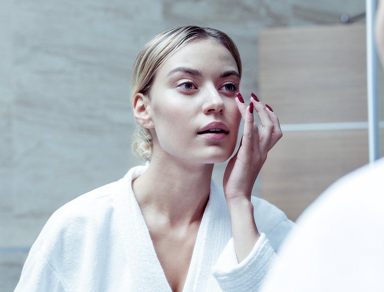 Woman applying facial skincare products