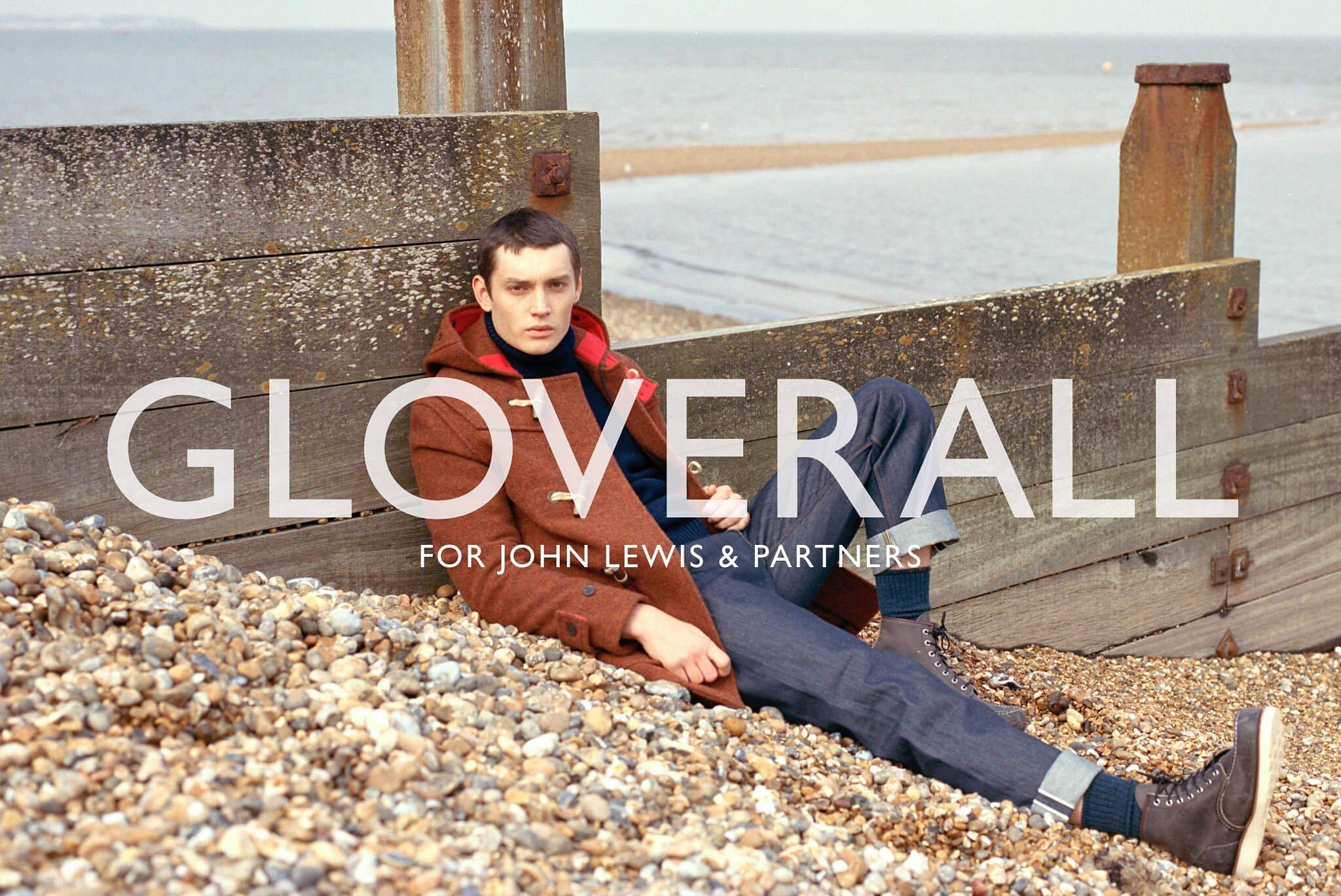 Male model on the beach in orange coat and blue jeans