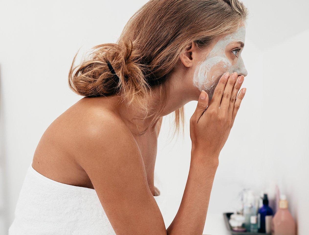 Woman washing face with cleanser