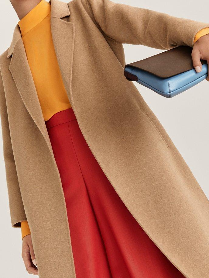 Model wearing coat, skirt and boots