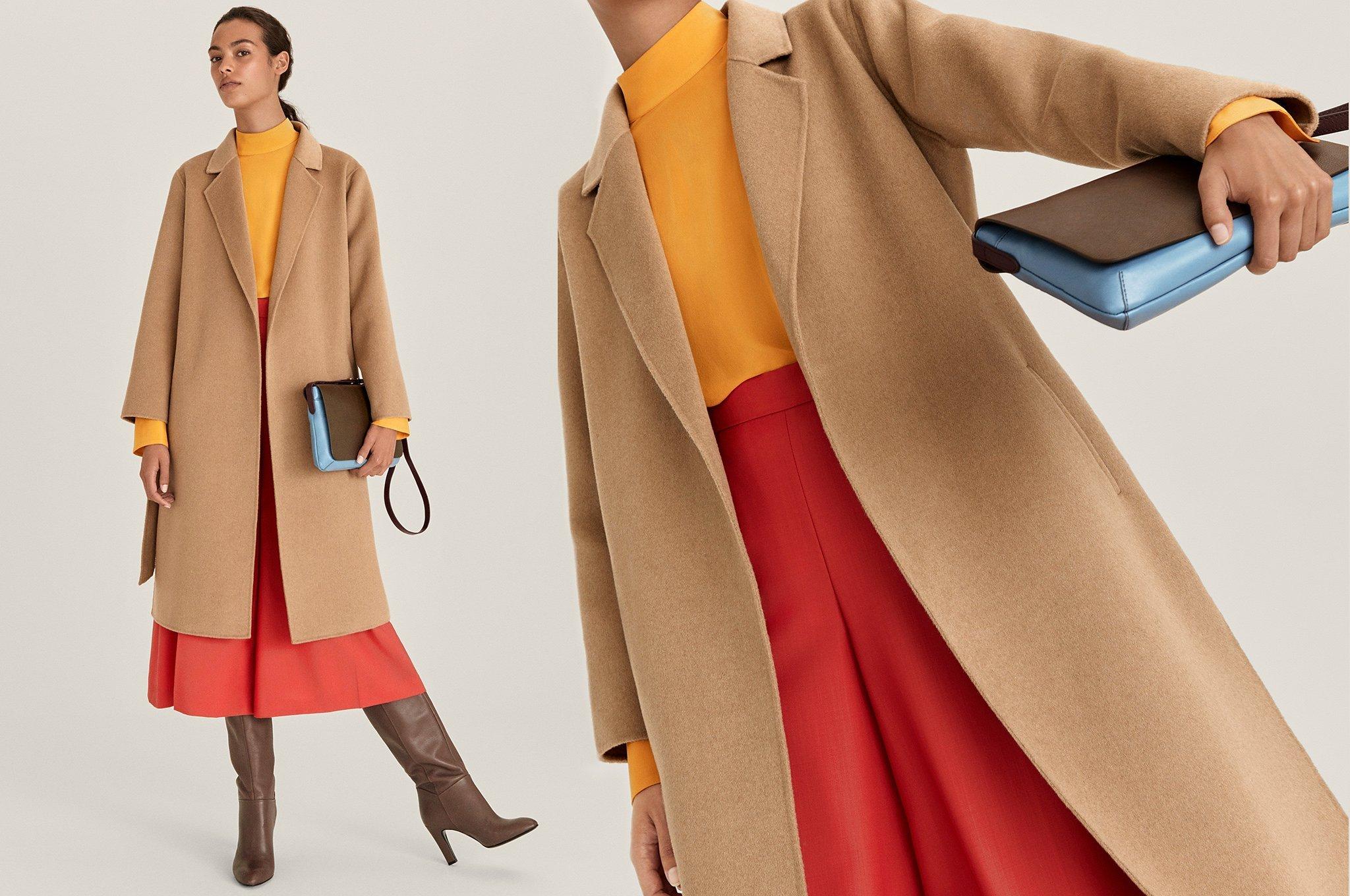 Model wearing camel coat, orange skirt and brown boots