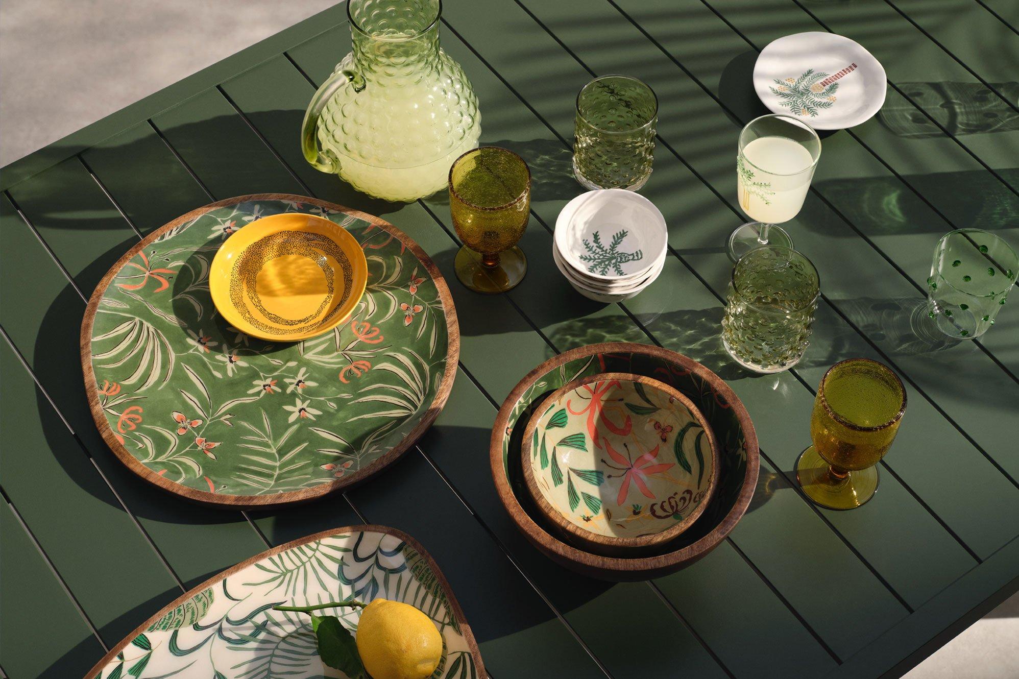 image of a green outdoor table with crockery on it